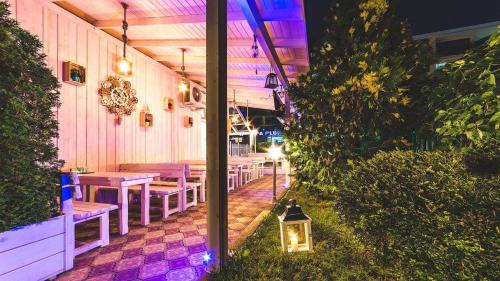 a restaurant with purple lighting and tables and benches at Beatris Family House in Sunny Beach