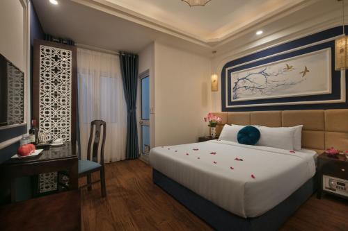a bedroom with a large white bed and a desk at Hanoi Chic Boutique Hotel in Hanoi