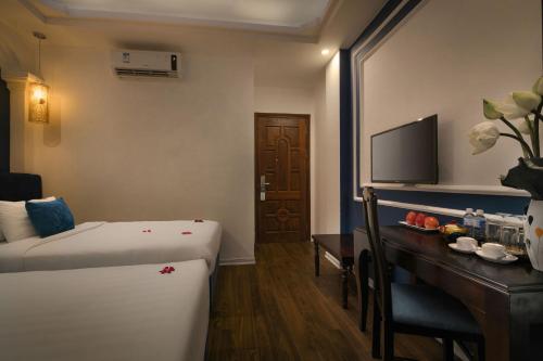 a hotel room with a bed and a desk and a television at Hanoi Chic Boutique Hotel in Hanoi
