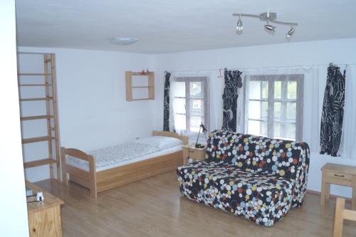 ヨセフーフ・ドゥールにあるChata Pekloのリビングルーム(ベッド1台、ソファ、椅子付)