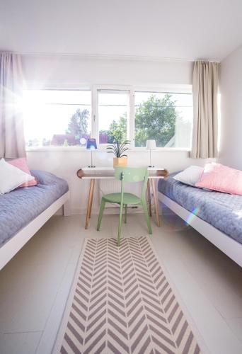 a bedroom with two beds and a table and a desk at Tamme Flint in Tartu
