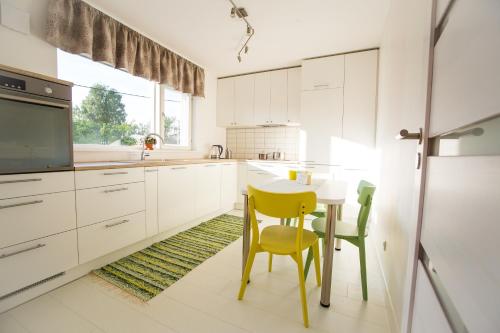 a kitchen with a small table and yellow chairs at Tamme Flint in Tartu