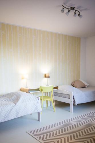 a bedroom with two beds and a desk and a table at Tamme Flint in Tartu