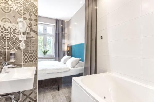 W łazience znajduje się umywalka, wanna i lustro. w obiekcie Hotel Kaliski w Słubicach
