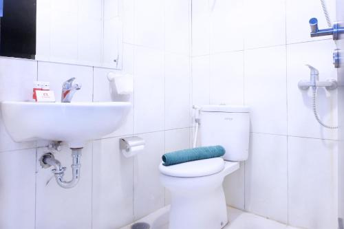 a bathroom with a white toilet and a sink at Nicest Apartment At Nifarro Park By Travelio in Jakarta