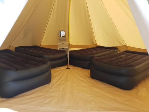 a tent with two couches in the middle at Herston Caravan & Camping in Swanage
