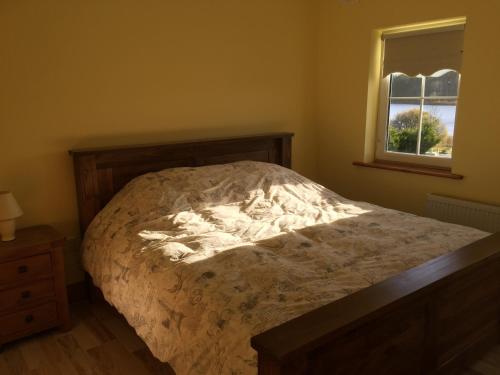 1 dormitorio con cama y ventana en Lakeview House en Castlefore
