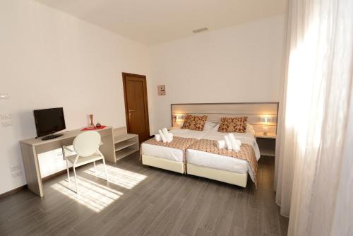 a bedroom with a bed and a desk and a television at BB Venice Cinzias' in Marghera