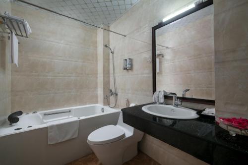 a bathroom with a tub and a toilet and a sink at Hanoi Chic Boutique Hotel in Hanoi