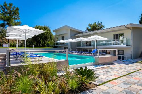 una villa con piscina e ombrelloni di The Elegant Apartments a Pefkari