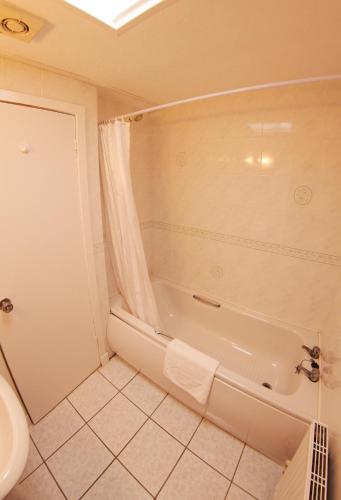 a bathroom with a shower and a tub and a toilet at Abbotsford Hotel in Dumbarton