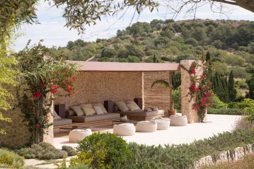 a patio with couches and flowers in a garden at Son Gener Hotel Spa in Son Servera