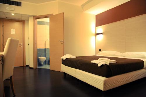 a hotel room with a bed and a bathroom at Hotel Sogni D'Oro Airport in Lamezia Terme