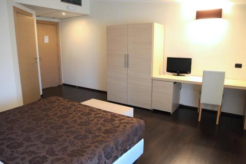 a bedroom with a bed and a desk with a computer at Hotel Sogni D'Oro Airport in Lamezia Terme