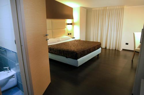 a hotel room with a bed and a bathroom at Hotel Sogni D'Oro Airport in Lamezia Terme