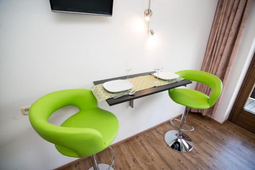 a room with two green chairs and a table at Haus Brandeck in Uttendorf