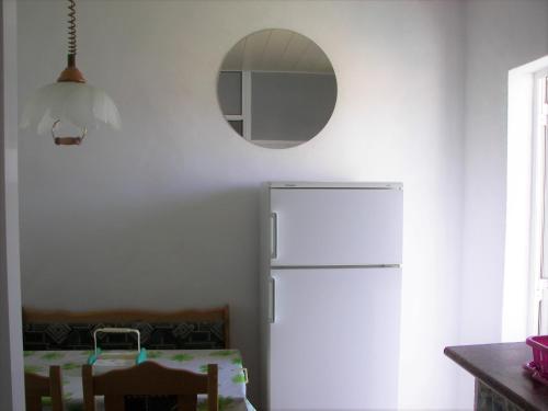 a kitchen with a white refrigerator and a mirror at Posada Chloe Santiago in Santiago de la Ribera