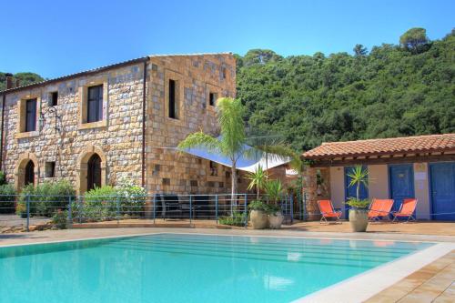 a house with a swimming pool in front of a building at Turismo Rurale Cefalù in Cefalù