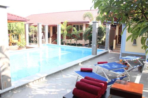 une piscine avec des chaises longues et une maison dans l'établissement Rimlay Park Resort, à Phatthalung