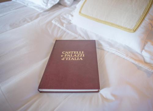 a book sitting on top of a bed at Castello Di Mornico Losana in Mornico Losana