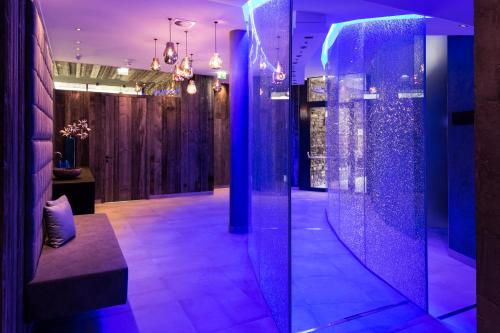 a room with purple lighting and a walk in shower at Verwöhnhotel Wildspitze in Sankt Leonhard im Pitztal