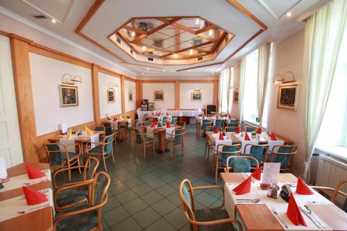 un restaurant avec des tables, des chaises et des serviettes rouges dans l'établissement Hotel U Divadla, à Znojmo