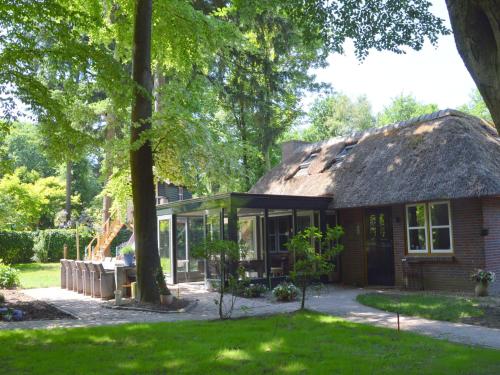 uma casa com telhado de palha e um quintal em Holiday home in Haaren near the Efteling em Haaren