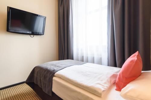 a hotel room with a bed and a flat screen tv at Hotel Fado Spa & Restaurant in Świdnica