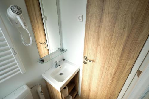 a small bathroom with a sink and a mirror at Terme Village - Mobile Homes in Čatež ob Savi