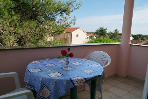 a table with a vase of flowers on a balcony at Apartment Privlaka 2 in Privlaka