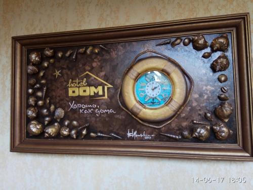 a picture of a frame with a clock and shells at ApartHotel Dom in Odesa