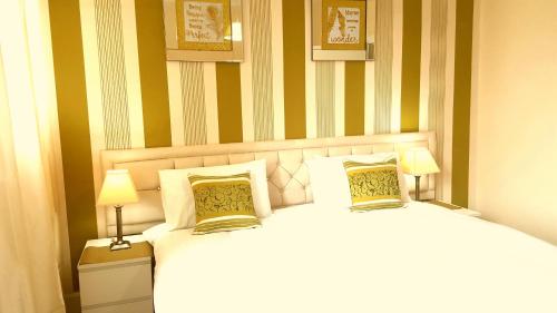 a bedroom with two beds and two lamps at Loch Lomond Apartments in Dumbarton