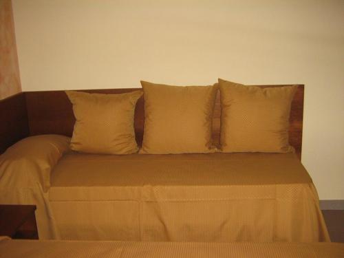 a bed with four pillows on top of it at Hostiliae Ciminiera Hotel in Ostiglia