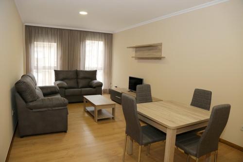 a living room with a table and chairs and a couch at Alojamiento Caldas de Reis in Caldas de Reis