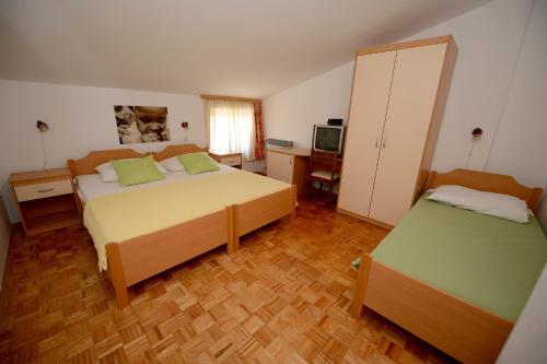 a bedroom with two beds and a desk and a television at Apartment Zadar 18 in Diklo