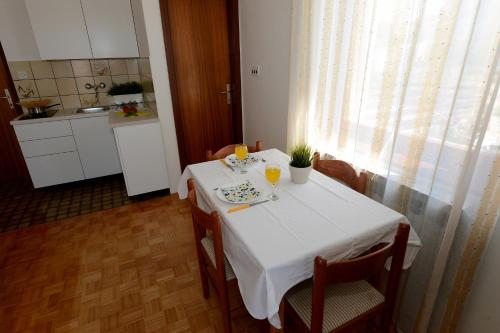 een tafel met een witte tafeldoek erop in een keuken bij Apartment Zadar 17 in Diklo