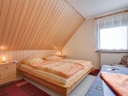 a bedroom with a bed with a wooden ceiling at Apartment Altenkirchen 2 im Dachgeschoss in Altenkirchen