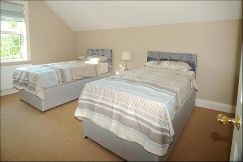 1 dormitorio con 2 camas y ventana en Homeplace Retreat Bellaghy Top Rated Property for Families Min 2 nights, en Bellaghy