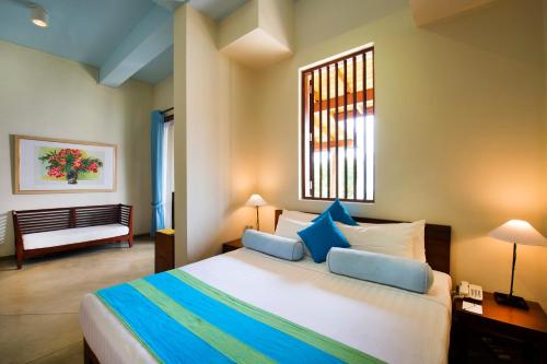 a bedroom with a large bed with blue pillows at Zylan Colombo in Colombo