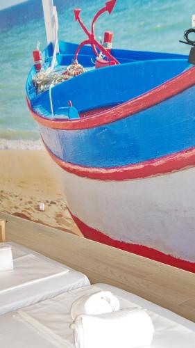 a blue and white boat sitting on the beach at Topcity Hostel & Suites in Lagos