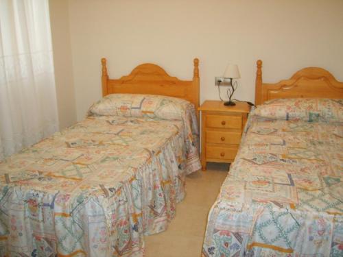 dos camas sentadas una al lado de la otra en un dormitorio en Apartamento con aire acondicionado en 1ª linea de playa edificio Molí de Vent, en Peñíscola