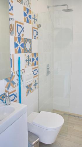 a bathroom with a toilet and a glass shower at Topcity Hostel & Suites in Lagos