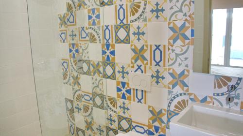 a bathroom with blue and white tiles on the wall at Topcity Hostel & Suites in Lagos