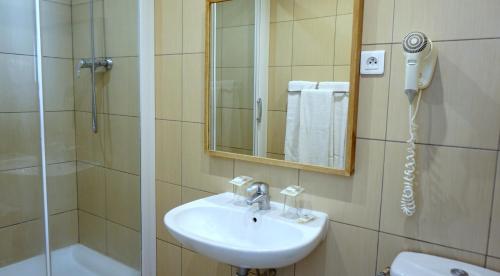 W łazience znajduje się umywalka, prysznic i lustro. w obiekcie Hôtel Liège Strasbourg w Paryżu