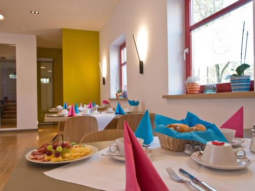 a dining room with a table with food on it at Avenon Privat-Hotel Am Steinberg in Röthenbach an der Pegnitz