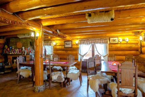 Pensiunea Haiducilor في بيستريتسا: غرفة طعام بجدران خشبية وطاولات وكراسي