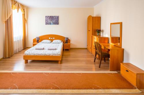 a bedroom with a bed and a desk and a mirror at Apartment On Yana Zhizhky in Lviv