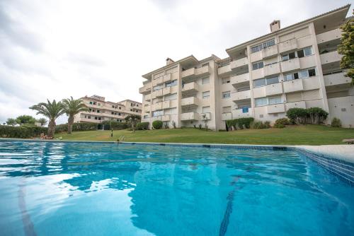 a large swimming pool in front of a building at La Marina de Aiguadolç in Sitges