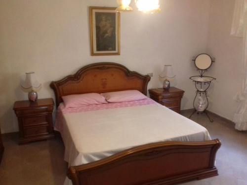 カステルサルドにあるCasa Castelsardoのベッドルーム1室(木製ベッド1台、ナイトスタンド2台付)