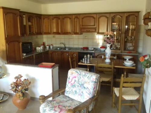 カステルサルドにあるCasa Castelsardoのキッチン(木製キャビネット、テーブル、椅子付)